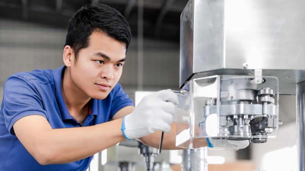 Technician inspecting a can packaging machine