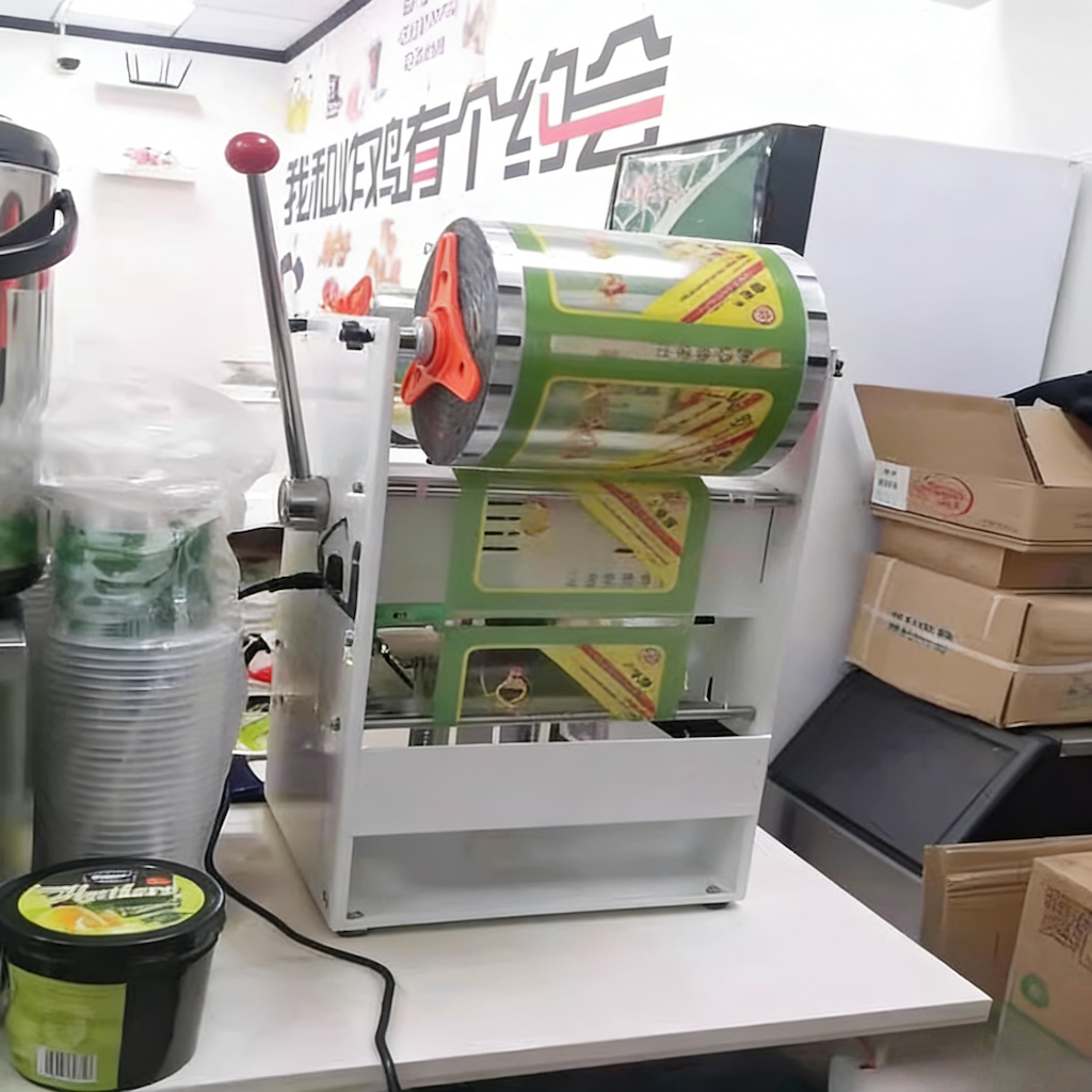 Compact tray sealing machine and sample lidding film in a workshop